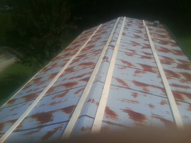 Rusted metal roof panels with new wood purlins before replacement — Storm Damage Roof Repair in Lillington by Roofing Brothers