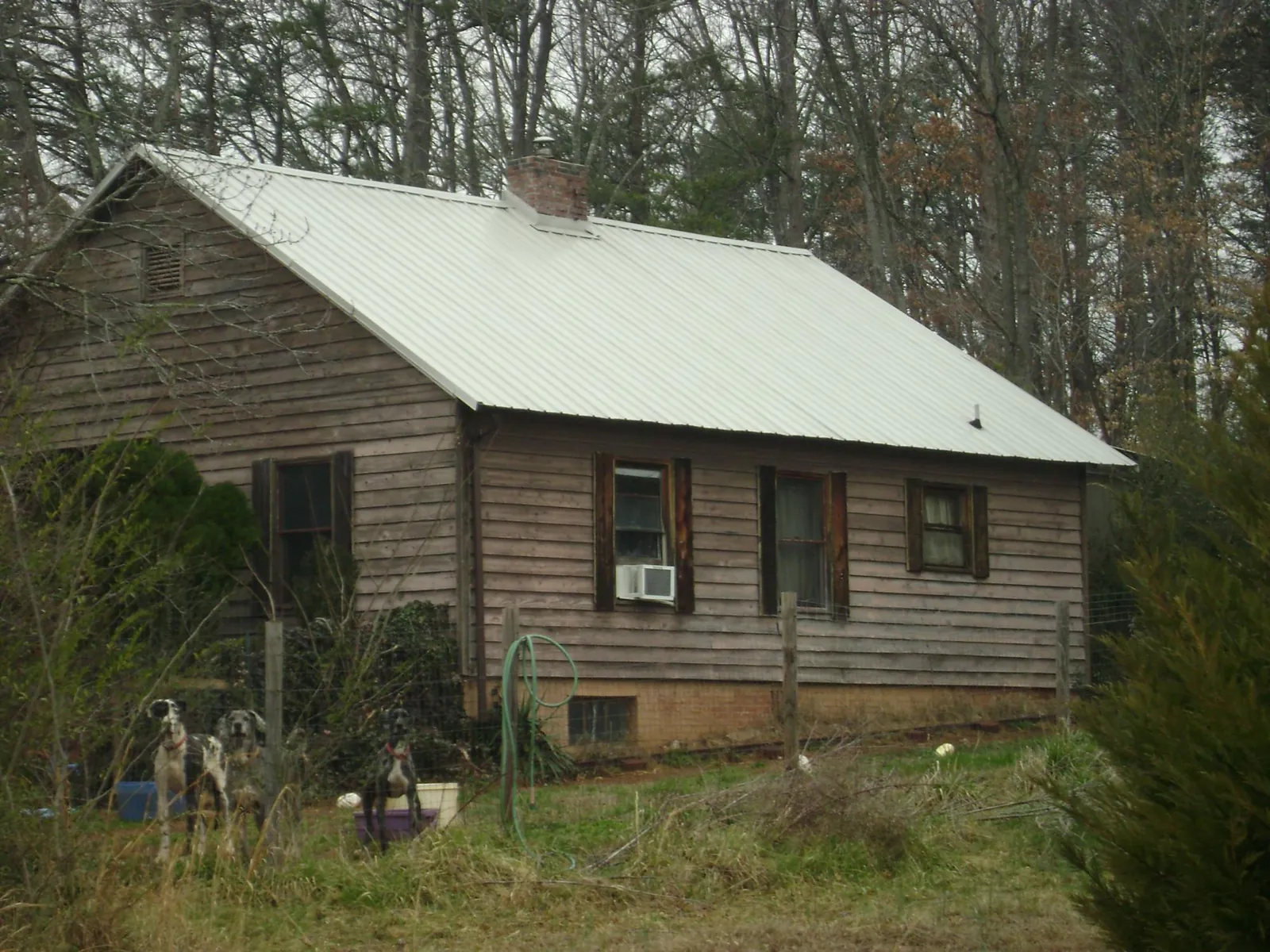 White metal roof on an old wood sided farmhouse, from a Metal Roof Installation job in Lillington